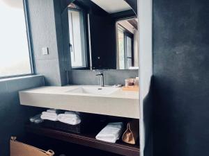 a bathroom with a sink and a mirror and towels at Mid Hill White Lodge in Mount Siguniang