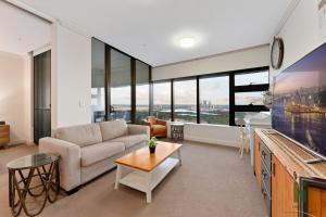a living room with a couch and a table at Best location apartment in Olympic park in Sydney