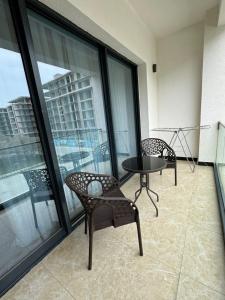 a balcony with two chairs and a table on a building at Sea breeze in Nardaran