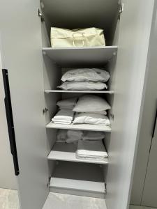 a closet filled with white shirts and towels at Sea breeze in Nardaran