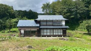 a house with a tin roof on a hill at 古民家かぐら in Tōno