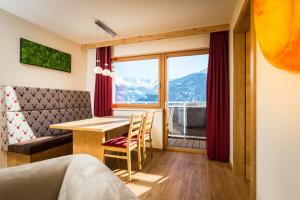 Zimmer mit einem Tisch und einem großen Fenster in der Unterkunft Luxapart in Ladis
