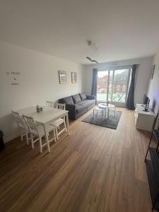 a living room with a table and a couch at Rozenhof - Appartement au coeur d'Armentieres in Armentières