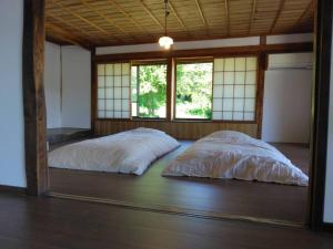 two beds in a room with a large mirror at 古民家かぐら in Tōno +13 photos