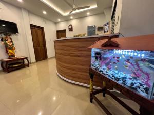 a room with a fish tank in front of a counter at Confident Residency in Guruvāyūr +16 photos