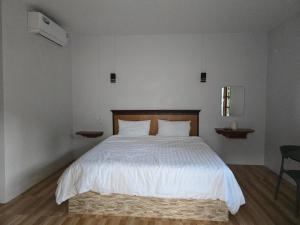 a bedroom with a large bed with white sheets at จันผารีสอร์ท By NLG in Ban Khok Khian +6 photos