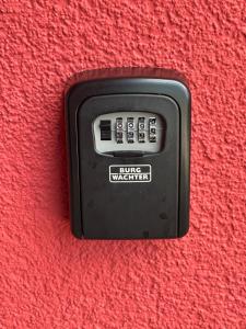 a black button on a red wall at Luna Apartment in Dinkelsbühl +5 photos