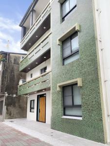 a green building with a door on the side of it at 青日所 Midoriya in Tainan