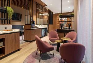 a hotel lobby with pink chairs and a bar at Wyndham Wroclaw Old Town in Wrocław
