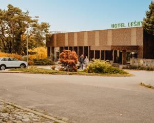 Un edificio con gente caminando frente a él. en Hotel Leśny, en Białystok
