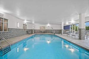 a swimming pool with blue water in a building at AmericInn by Wyndham International Falls in International Falls