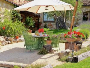 a table and chairs under an umbrella in a garden at Villa Solace - Comfort Charm in Guardea