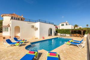 a villa with a swimming pool and lounge chairs at Villa Claudia by Villa Plus in S'Algar