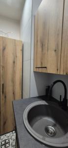 a bathroom with a sink and wooden cabinets at Mihail Residence - Relax in Kavala in Kavala +28 photos
