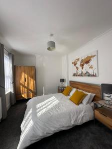 a bedroom with a large white bed with yellow pillows at 3 bed Spacious House with Parking in Worthing