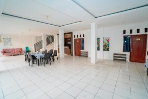 a dining room and living room with a table and chairs at Hotel Andalusia Darunnajah 3 in Pabuwaran 3