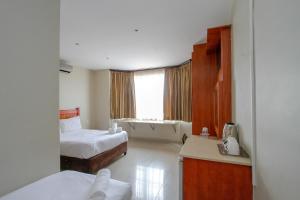 a hotel room with two beds and a window at PLM Lodge in Durban