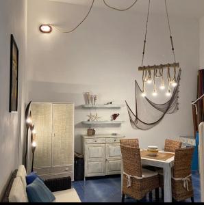 a kitchen with a table and chairs and a chandelier at Casa Ada - Incantevole loft in centro in Lampedusa