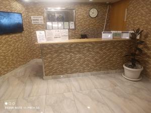 a lobby with a counter with a clock on the wall at شقق ريف نماص للوحدات السكنية in Al Namas
