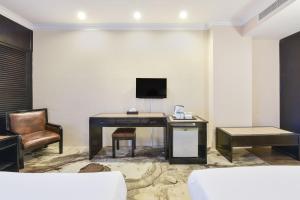 a room with a desk with a television and a chair at Sunday Malacca Formerly Tun Fatimah in Malacca