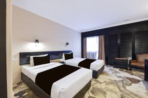 a hotel room with two beds and a couch at Sunday Malacca Formerly Tun Fatimah in Malacca