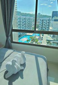 Arcadia beach resort في جنوب باتايا: سرير عليه حشرتين محشوتين امام النافذه