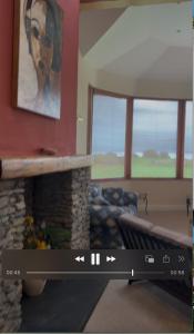 a living room with a couch and a fireplace at Stunning Waterfront House on Lough Currane Shores in Waterville