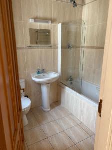 a bathroom with a sink and a toilet and a tub at Stunning Waterfront House on Lough Currane Shores in Waterville