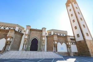 Un gran edificio con una torre de reloj y una puerta. en Camera Agadir, en Agadir