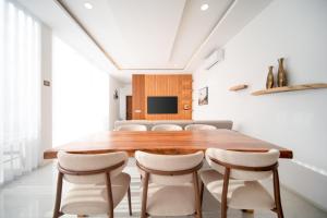 a dining room with a wooden table and white chairs at Luxury Tropical Villa Samui - Shira in Koh Samui 