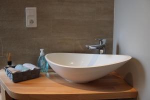 a white bowl sink on a wooden table in a bathroom at Le Manoir de l'Abbaye in Saverne