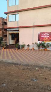 a building with potted plants in front of it at Hotel A1 family restaurant Bar & Lodge in Birvādi
