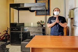 a man wearing a mask in a kitchen with a table at OYO Life 92630 Siliwangi Residence 63 in Bandung