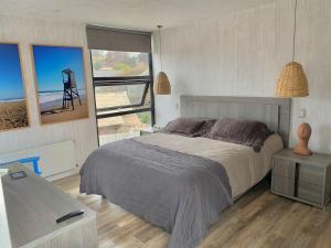 a bedroom with a bed and a view of the ocean at Moderna casa laguna zapallar, 1 cuadra de la playa in La Laguna Zapallar