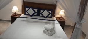 a bedroom with a bed with two lamps and towels at Ceylon Kingsmen Garden - Katunayake Airport Transit Hotels in Negombo