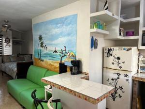 a living room with a green couch and a refrigerator at Departamento San Carlos Sonora in Rancho El Pozo