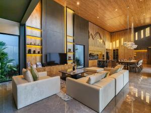 a living room with white couches and a television at Villa Narda Seminyak by Nagisa Bali in Legian