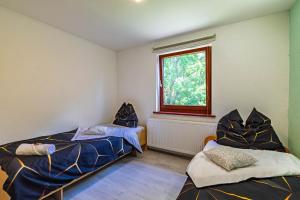 a bedroom with two beds and a window at Ruhig gelegenes Reihenhaus Nähe Europapark & Messe, Haustiere kostenlos für Familien und Geschäftsreisende, Rechnung auf Anfrage möglich in Offenburg