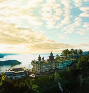 a group of buildings on a hill with a body of water at Taman Simalem Resort in Tongging