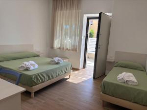 a bedroom with two beds with towels on them at Don Rosario in Stazione di Paestum