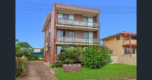 a brick building with a balcony on the side of it at Rocky Beach unit in Port Macquarie