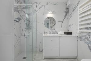 ウニエシチェにあるSea&Lake Mielno Unique Studio for a Family Holiday by the Sea Balcony & Parking by Noclegi Rentersの白いバスルーム(シャワー、鏡付)