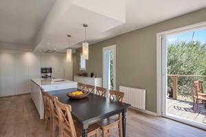 una cucina e una sala da pranzo con tavolo e sedie di Villa Le Corps de Garde a Furiani Altre 39 foto