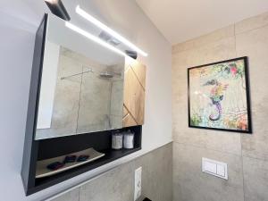 a bathroom with a mirror and a painting on the wall at W&D Living-Kunstvoll-Gespannparkplatz & Terrasse in Celle +50 photos