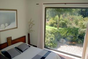 a bedroom with a large window looking out at a garden at Serene retreat in Rhodes Town