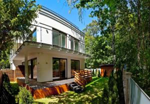 a white house with a fence and trees at Bursztynowa Zatoka BlueApart Jurata in Jurata