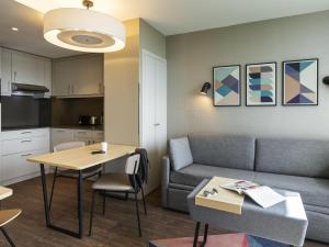 a living room with a couch and a table at Aparthotel Adagio London Stratford in London