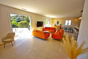 una sala de estar con 2 sofás naranjas y una mesa. en Villa E Cotule, en Santa-Reparata-di-Balagna 31 fotos más