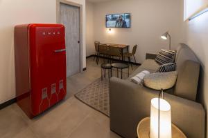 a living room with a red refrigerator and a couch at TRIA NOMINA Apartamentos Turísticos in Mérida