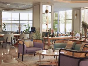 een lobby met stoelen, tafels en ramen bij Mercure Anyang Downtown in Anyang